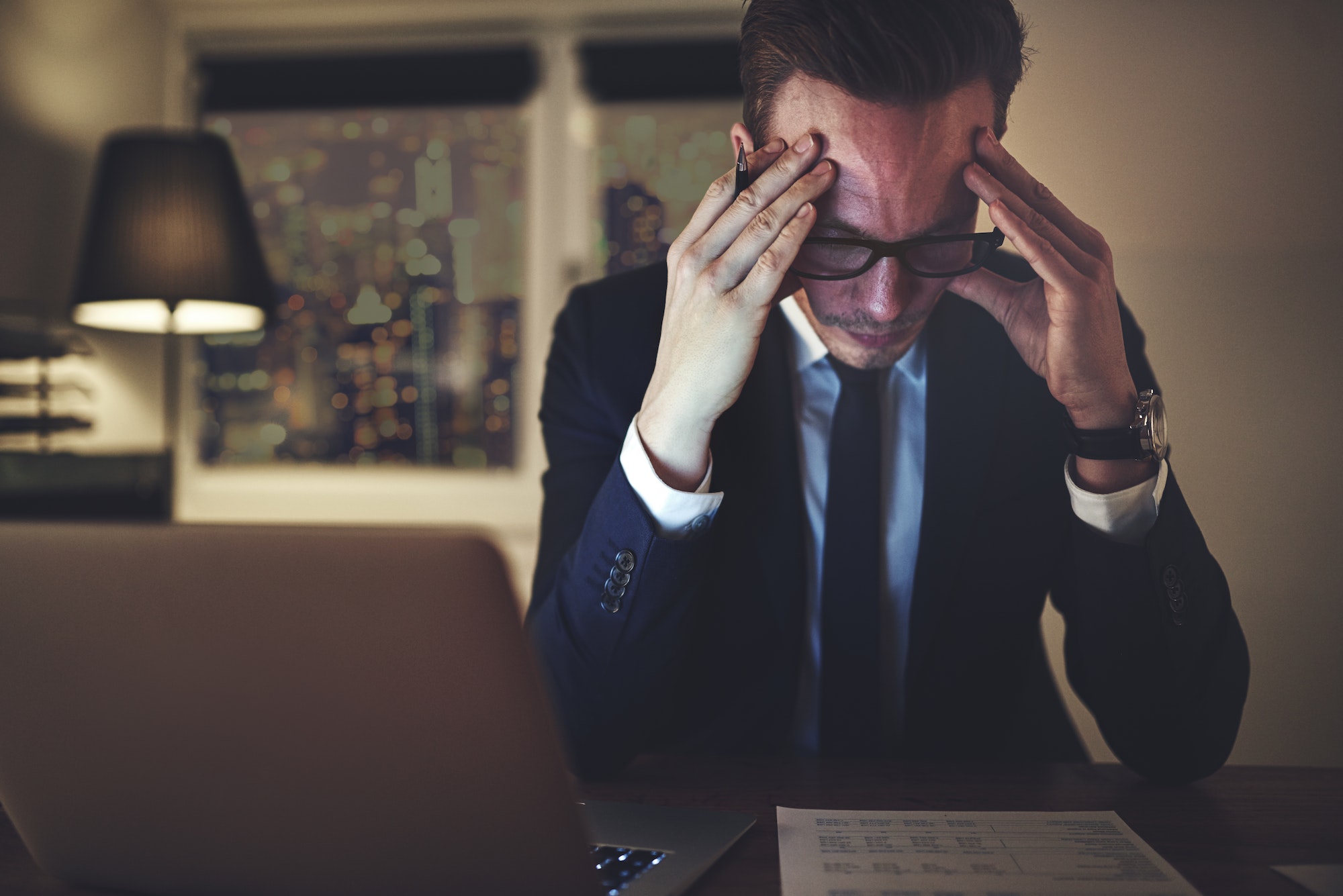 Pensive office worker accounting in the evening Pensive office worker accounting in the evening
